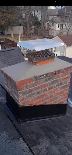 A brick chimney is sitting on top of a roof.