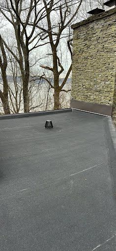 A roof with a hole in it and trees in the background.