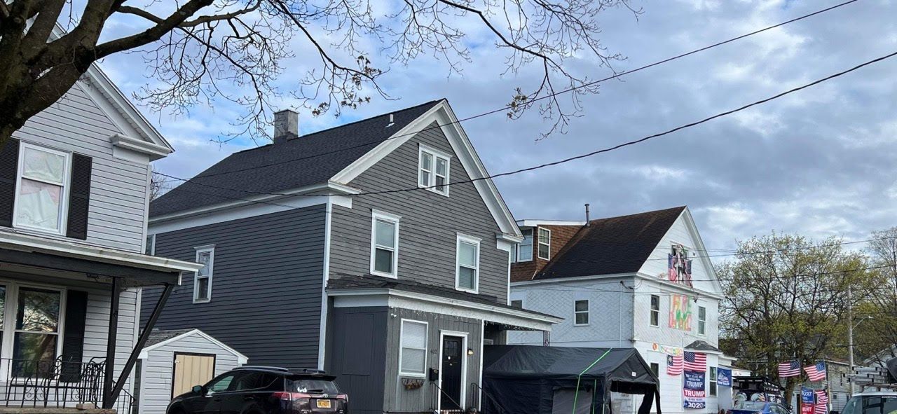 A car is parked in front of a row of houses.