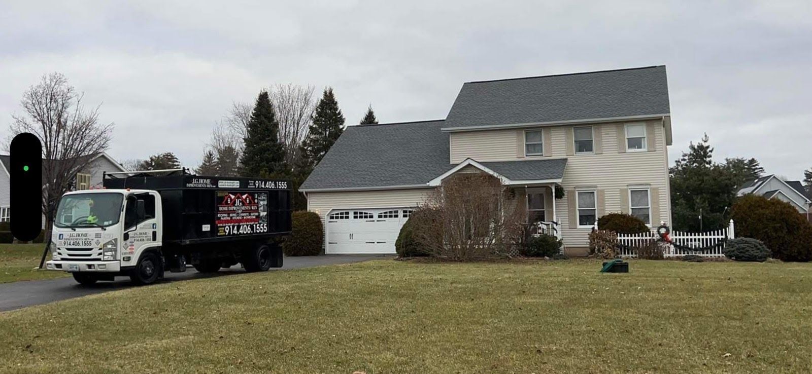 A dump truck is parked in front of a house.
