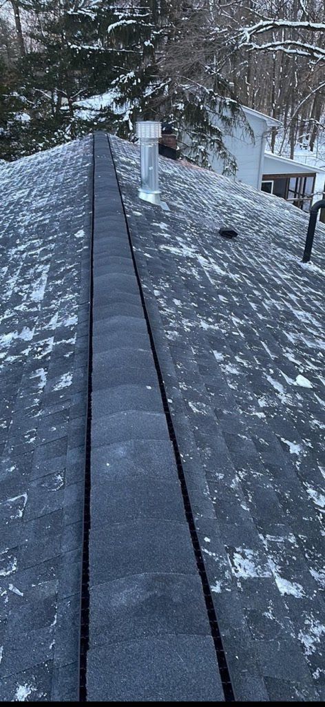 A snowy roof with a chimney on top of it.