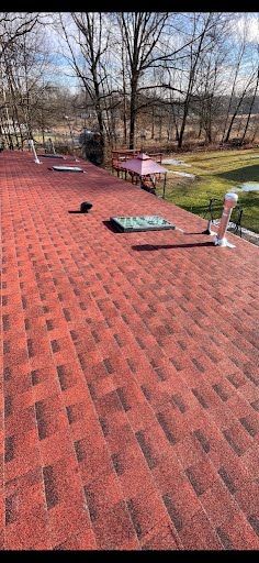 A red roof with a skylight on top of it.