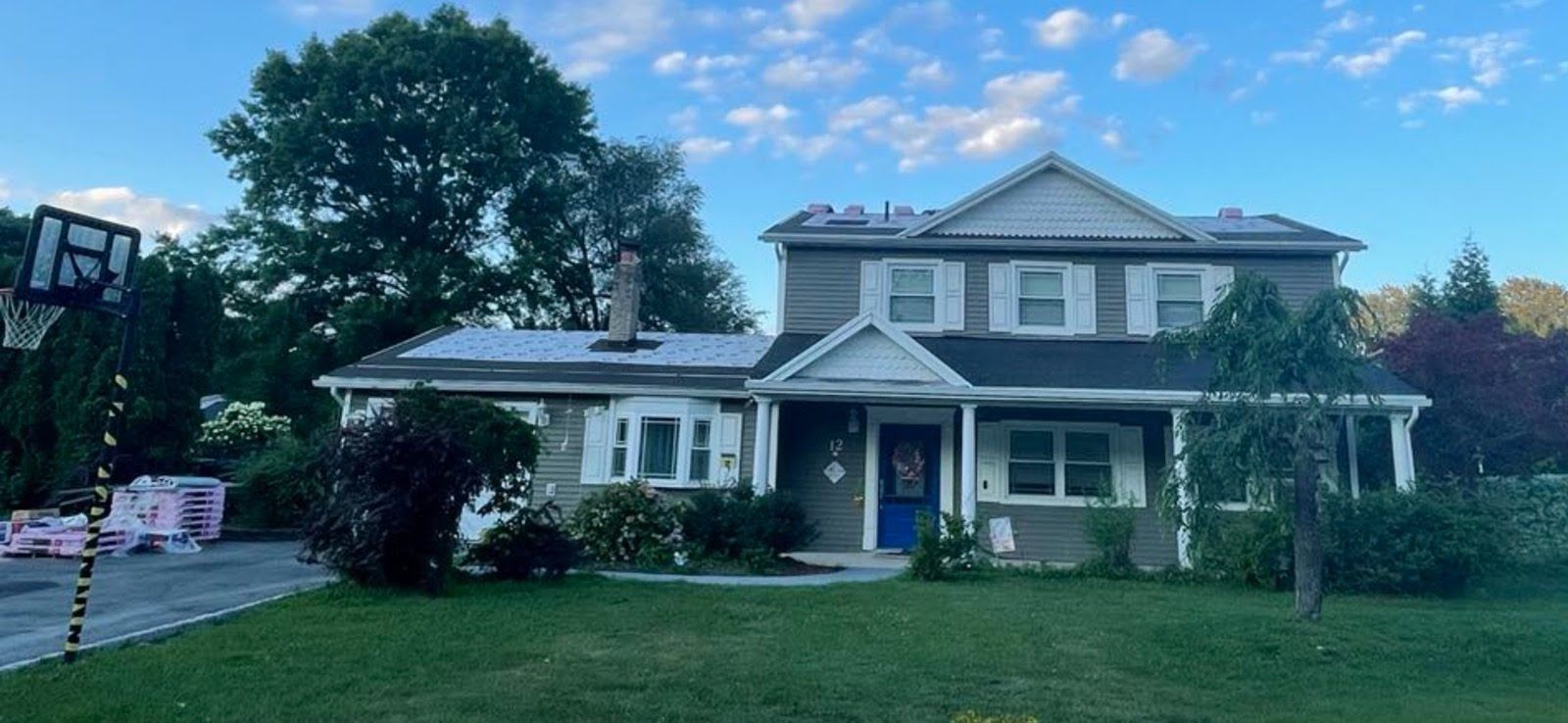 A large house with a blue door is sitting on top of a lush green lawn.