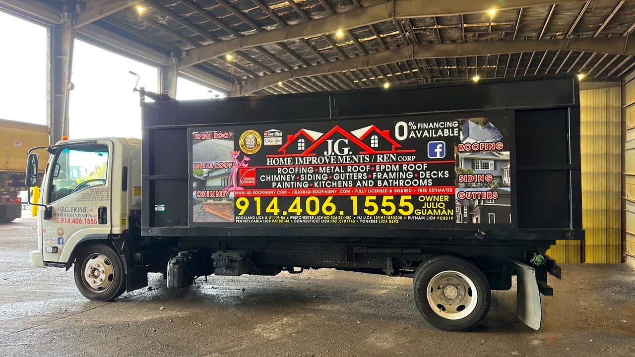 Black dump truck with company advertisement; phone number 914.406.1555.