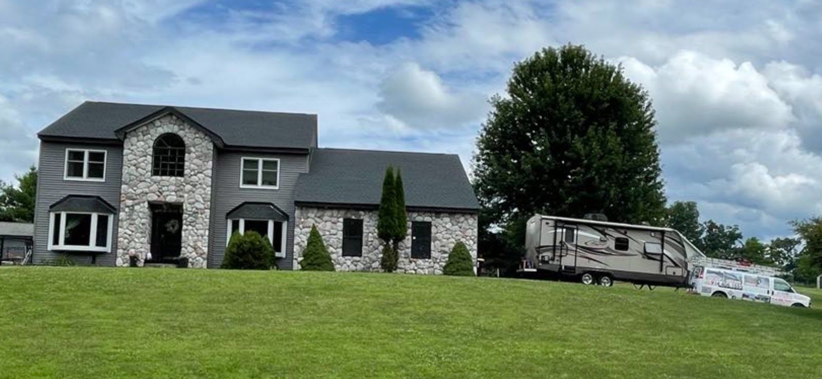 A large house with a rv parked in front of it.