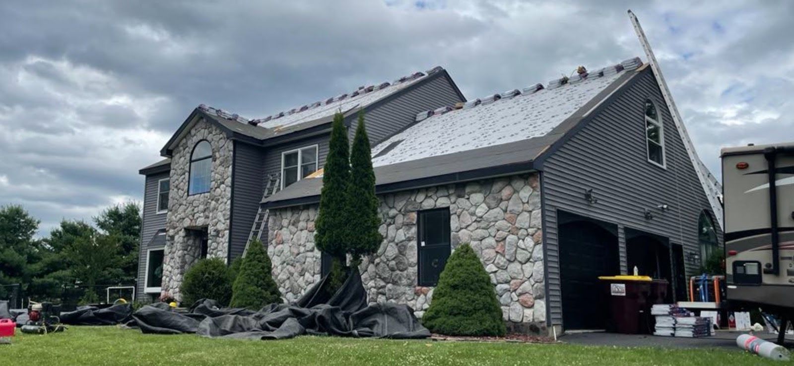 A large stone house with a roof that is being installed.