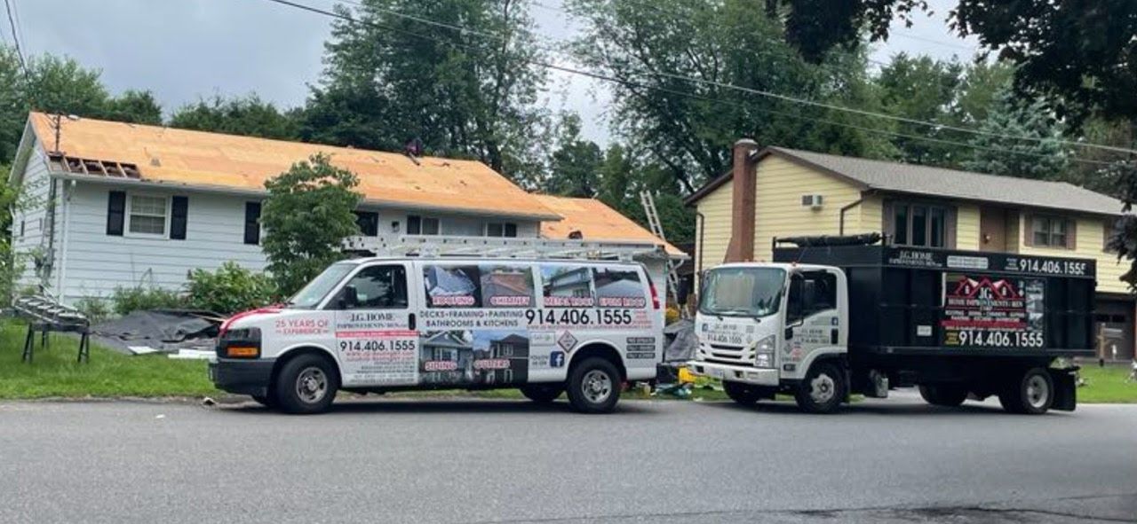 Two trucks are parked on the side of the road in front of a house.
