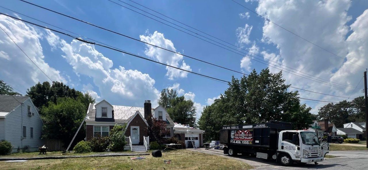 A truck is parked in front of a house on a sunny day.