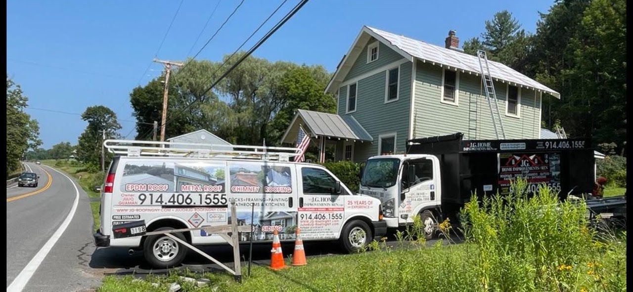 Two vans are parked in front of a house on the side of the road.
