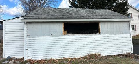 A white garage with a window cut out of it.