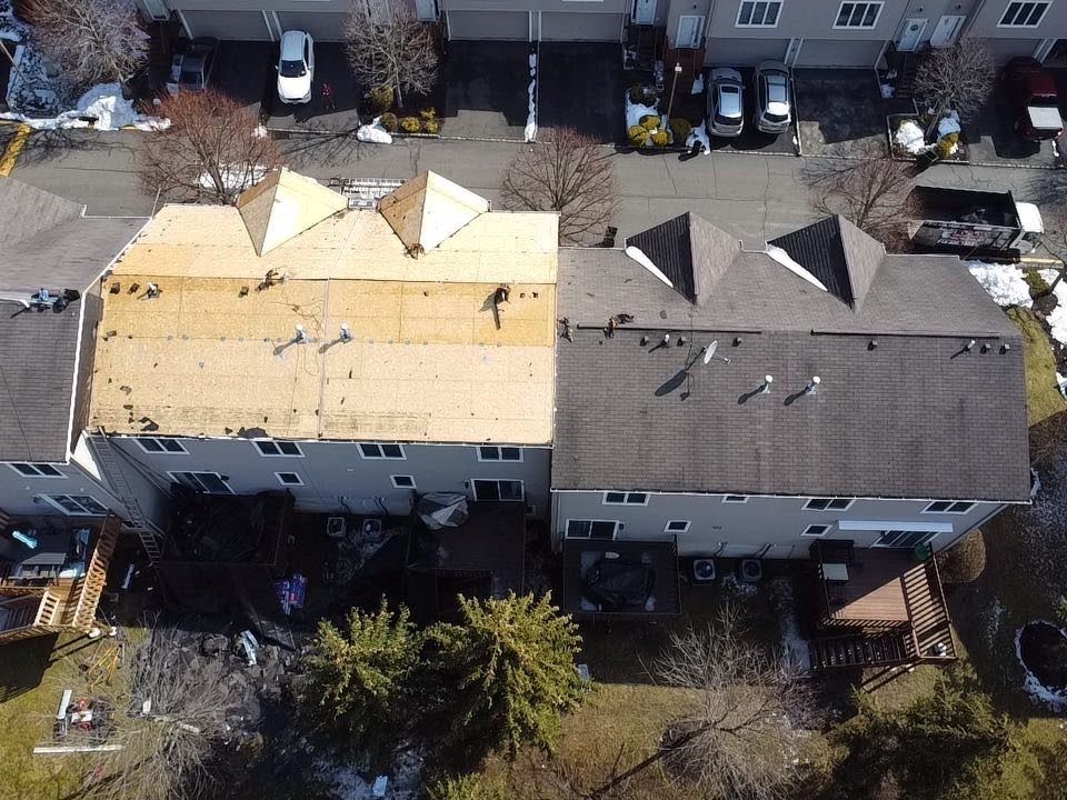 An aerial view of a house with a roof that is being repaired