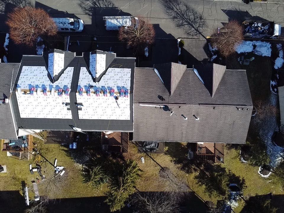 An aerial view of a house with a white roof
