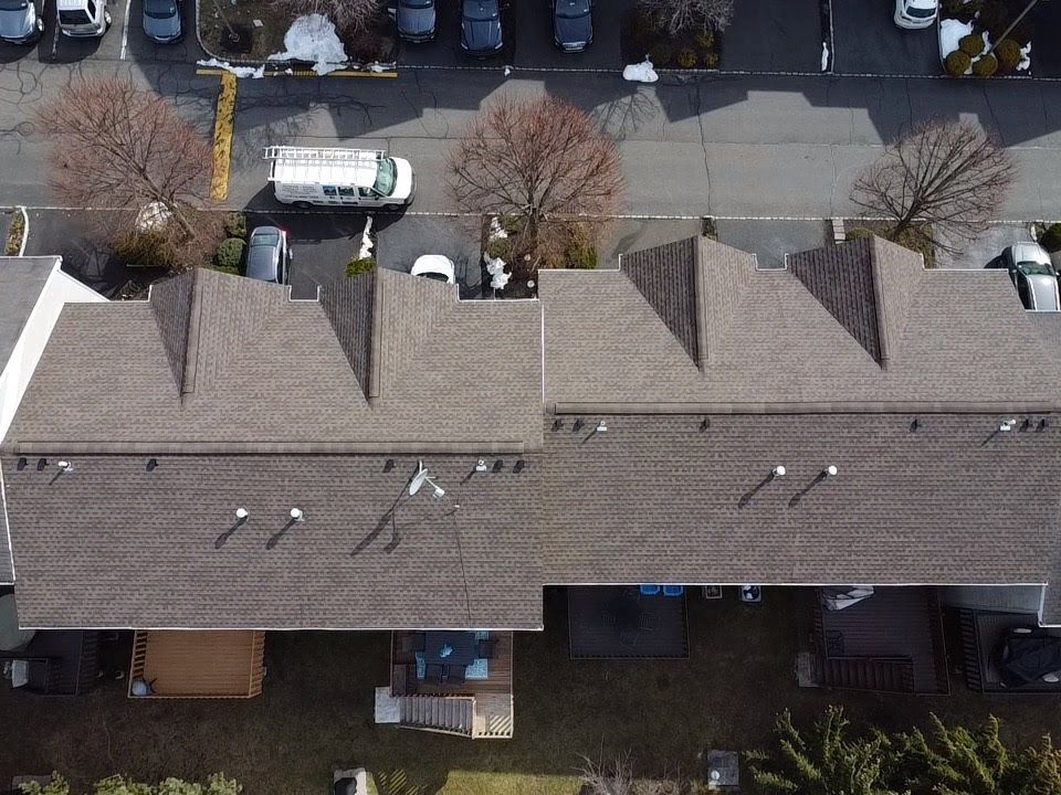 An aerial view of a house with a van parked in front of it.