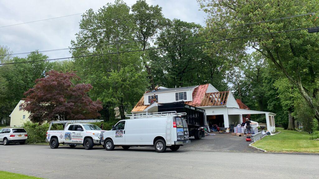A row of vans are parked in front of a house.