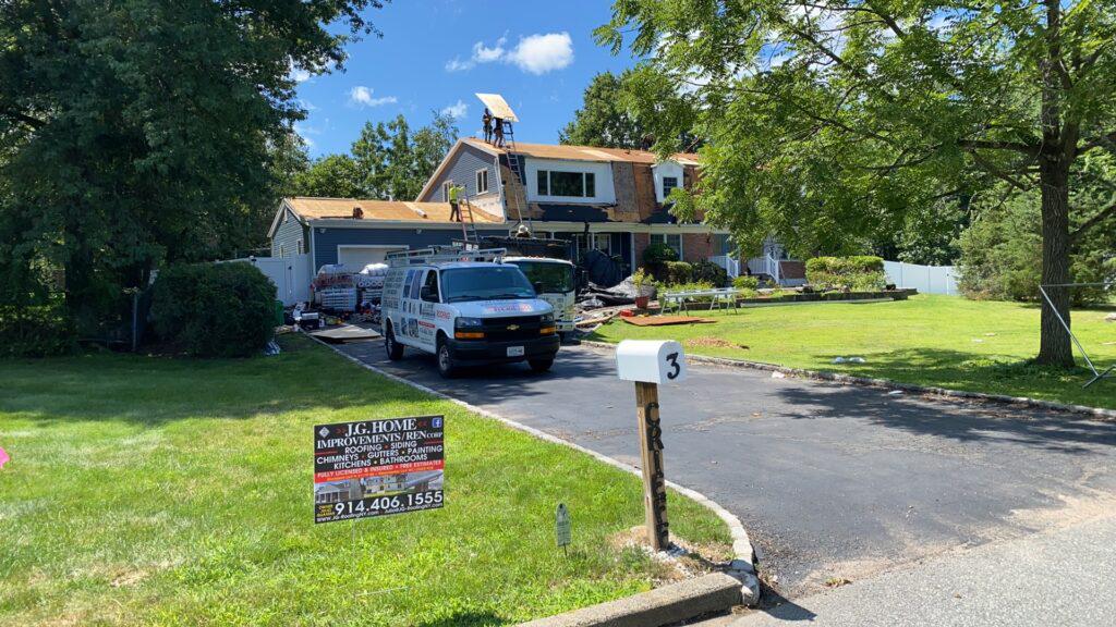 A white van is parked in front of a house.