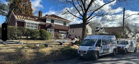 A couple of vans parked in front of a house.