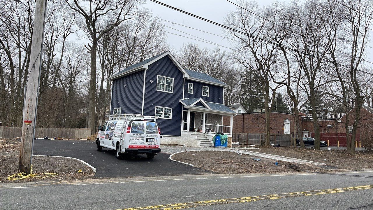 A blue house with a white van parked in front of it