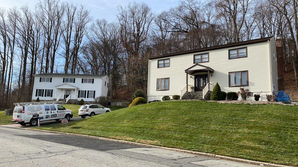A couple of houses are sitting next to each other on a hill.