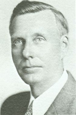 A black and white photo of a man in a suit and tie.