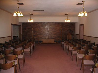 An empty church with rows of chairs and a wooden wall
