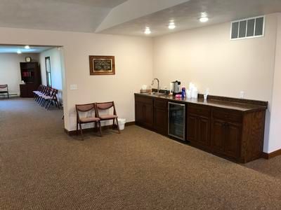 A large room with a counter and chairs in it.