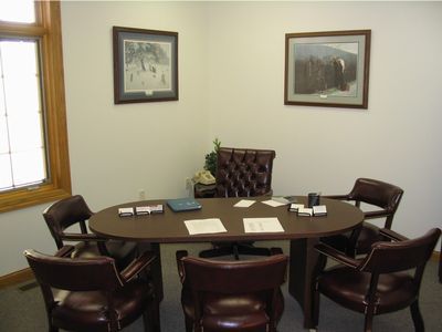 A conference room with a round table and chairs