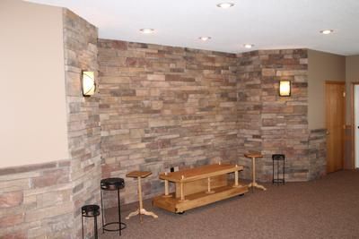 A room with a stone wall and a wooden table in it.