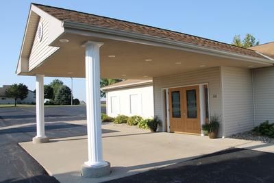 A white building with a canopy over the entrance