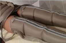 Une personne est allongée sur un lit avec une machine sur ses jambes.