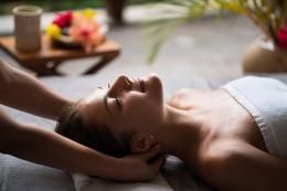 Une femme reçoit un massage de la tête dans un spa.