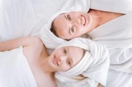 Deux femmes sont allongées sur un lit avec des serviettes enroulées autour de leur tête.