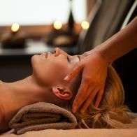 Une femme reçoit un massage de la tête dans un spa.