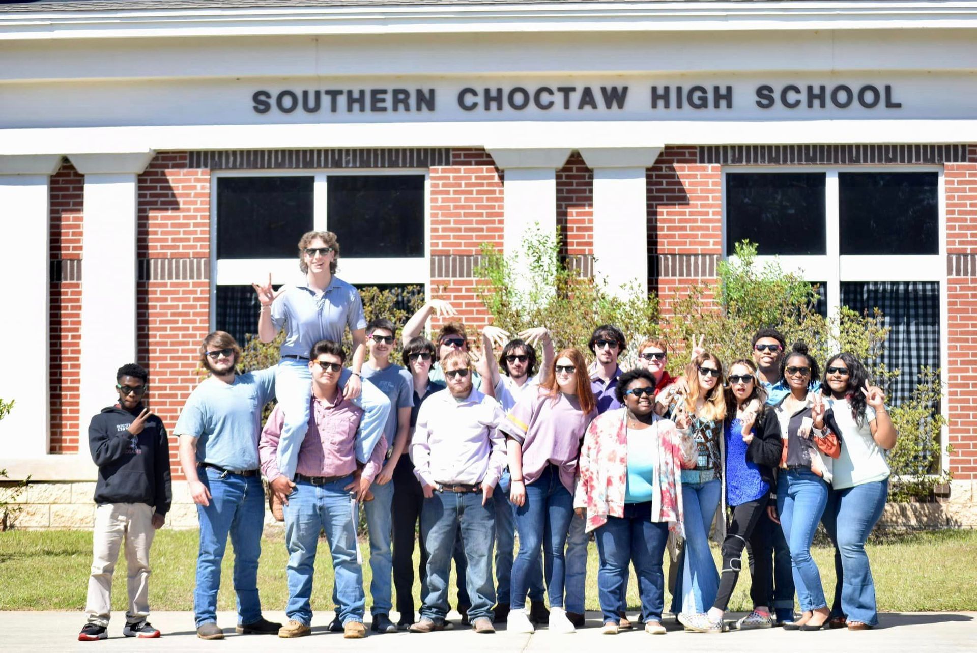 a group of people are posing for a picture in front of southern choctaw high school .