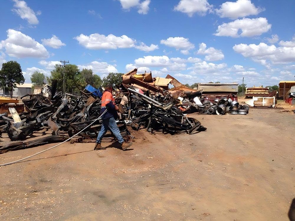 Man Walks Through A Large Pile Of Scrap Metal