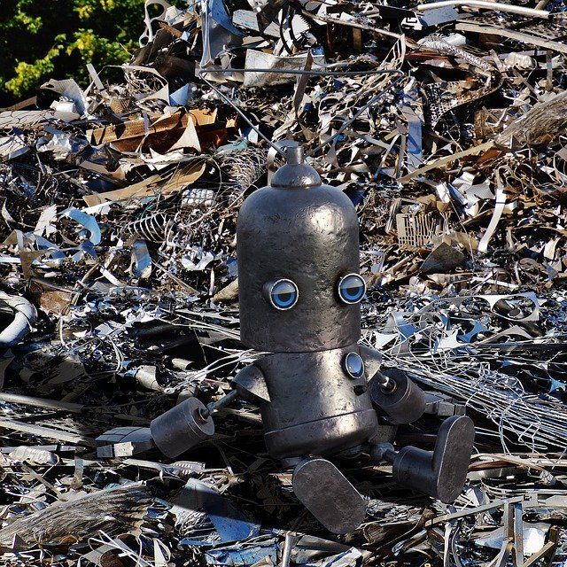 metal robot sitting in metal recycling station