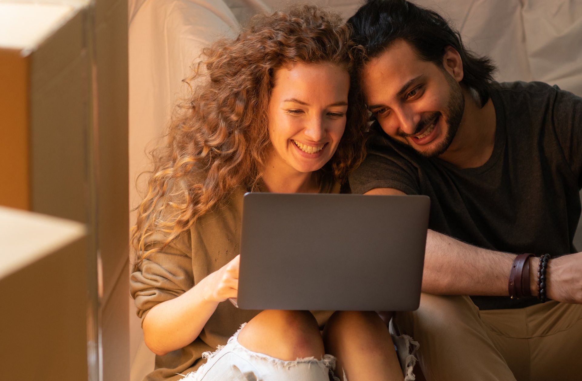 A young couple uses their laptop computer to search for a home online.