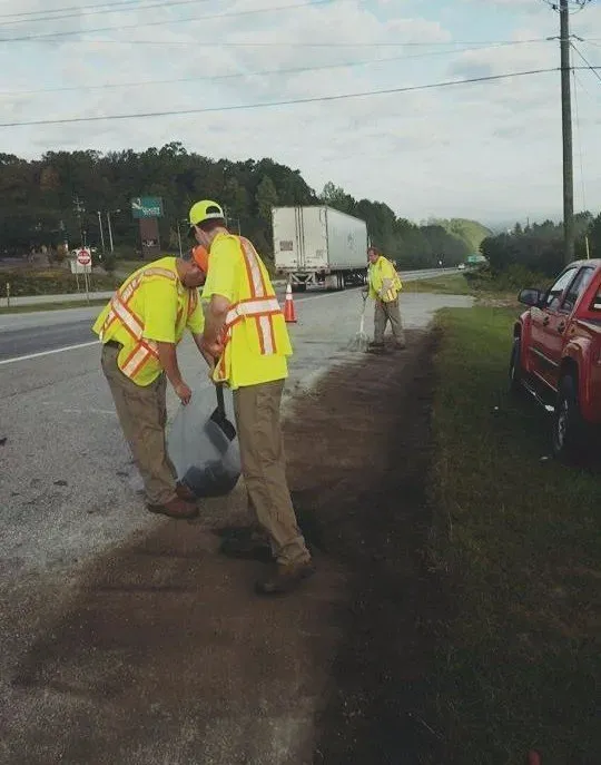Workers spreading soil on the side of the road — Ashford, AL — Environmental & Hazmat Services Inc.