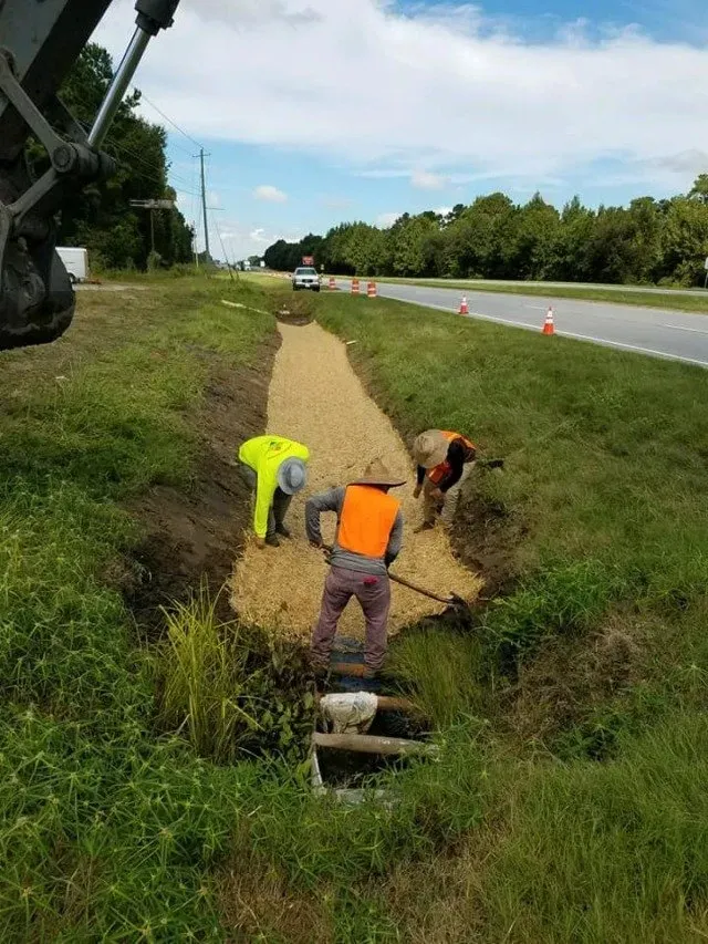 Workers distributing the hay on the pit — Ashford, AL — Environmental & Hazmat Services Inc.
