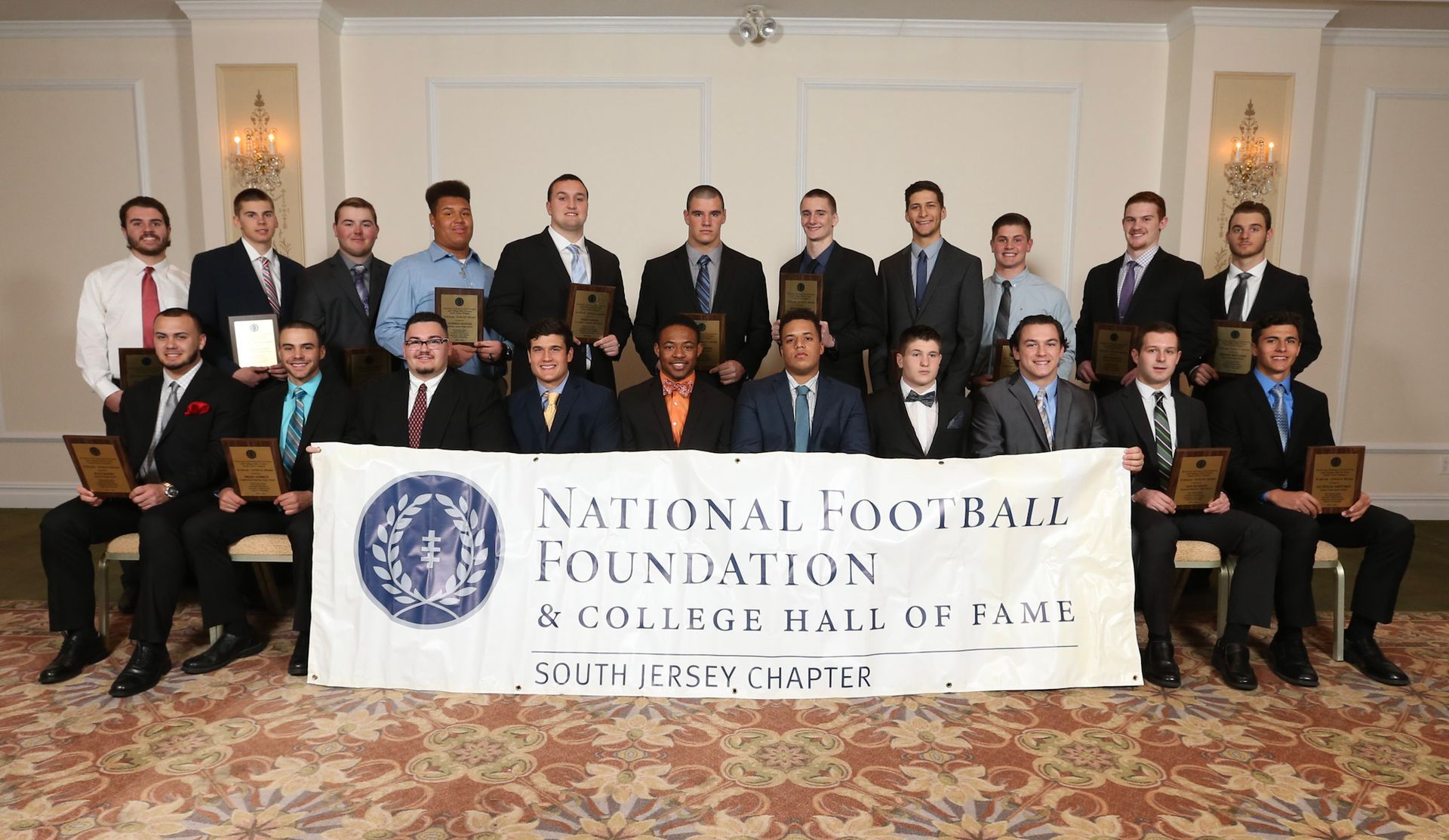 a group of men holding a national football foundation banner