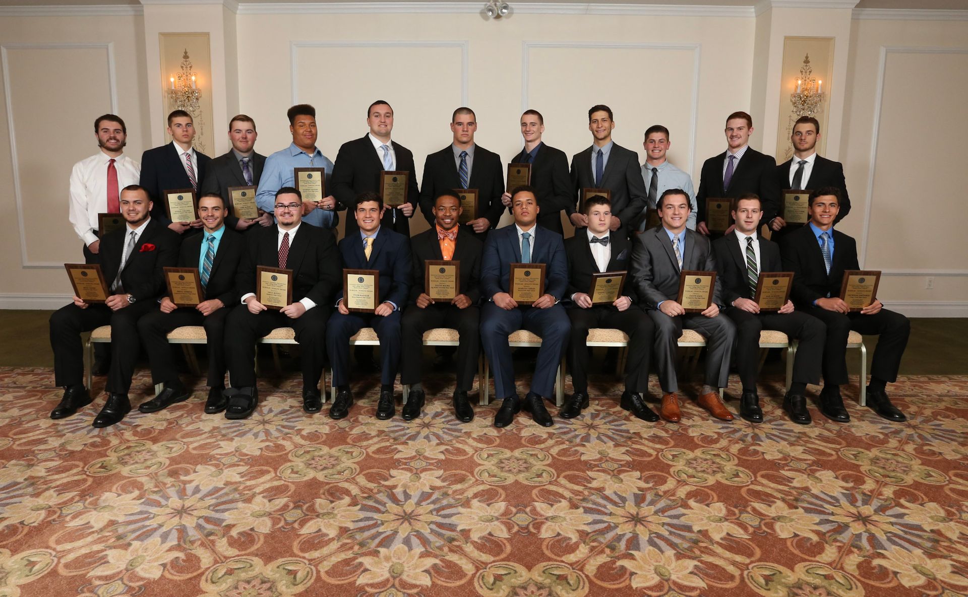 a group of men are posing for a picture holding plaques