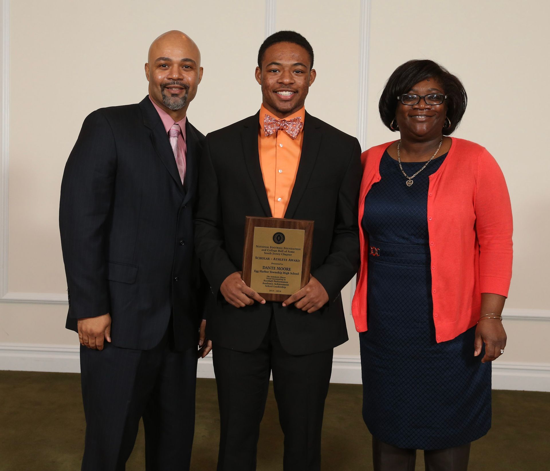a man in a suit is holding a plaque that says ' winner ' on it