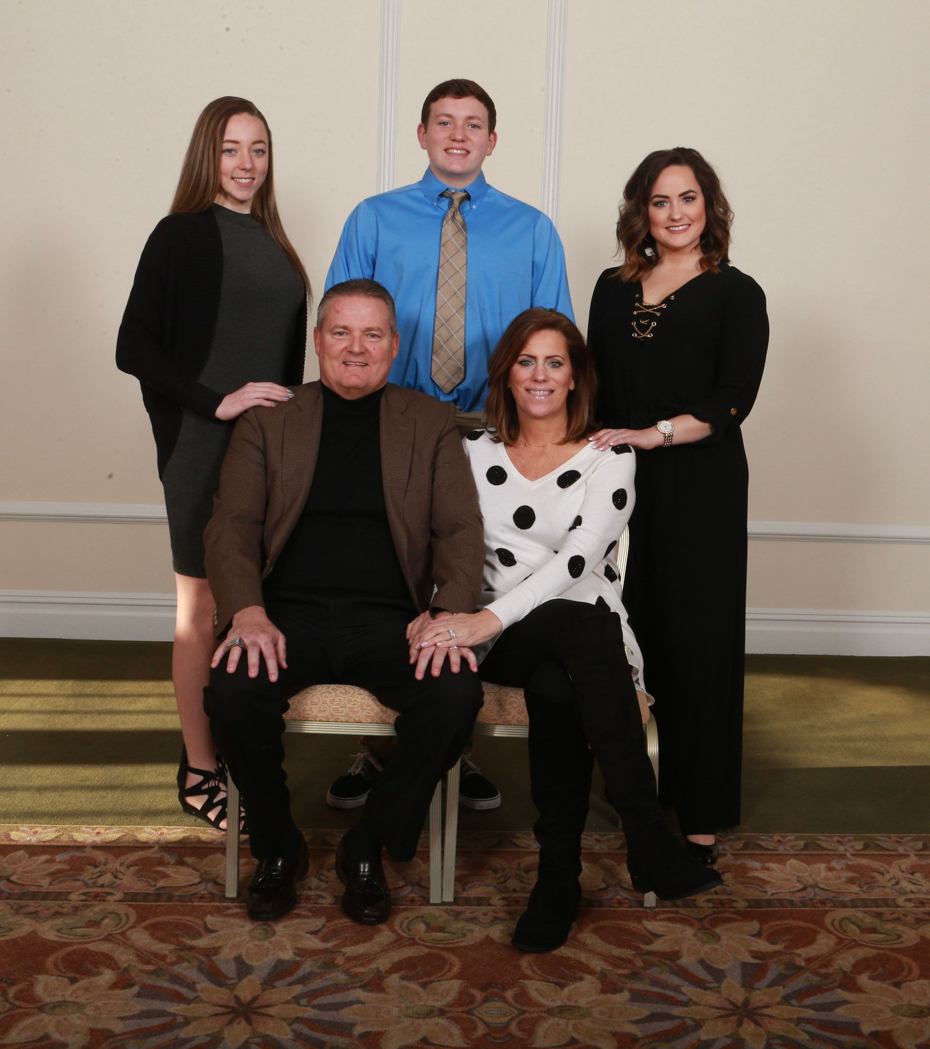 a group of people posing for a picture including a man in a blue shirt