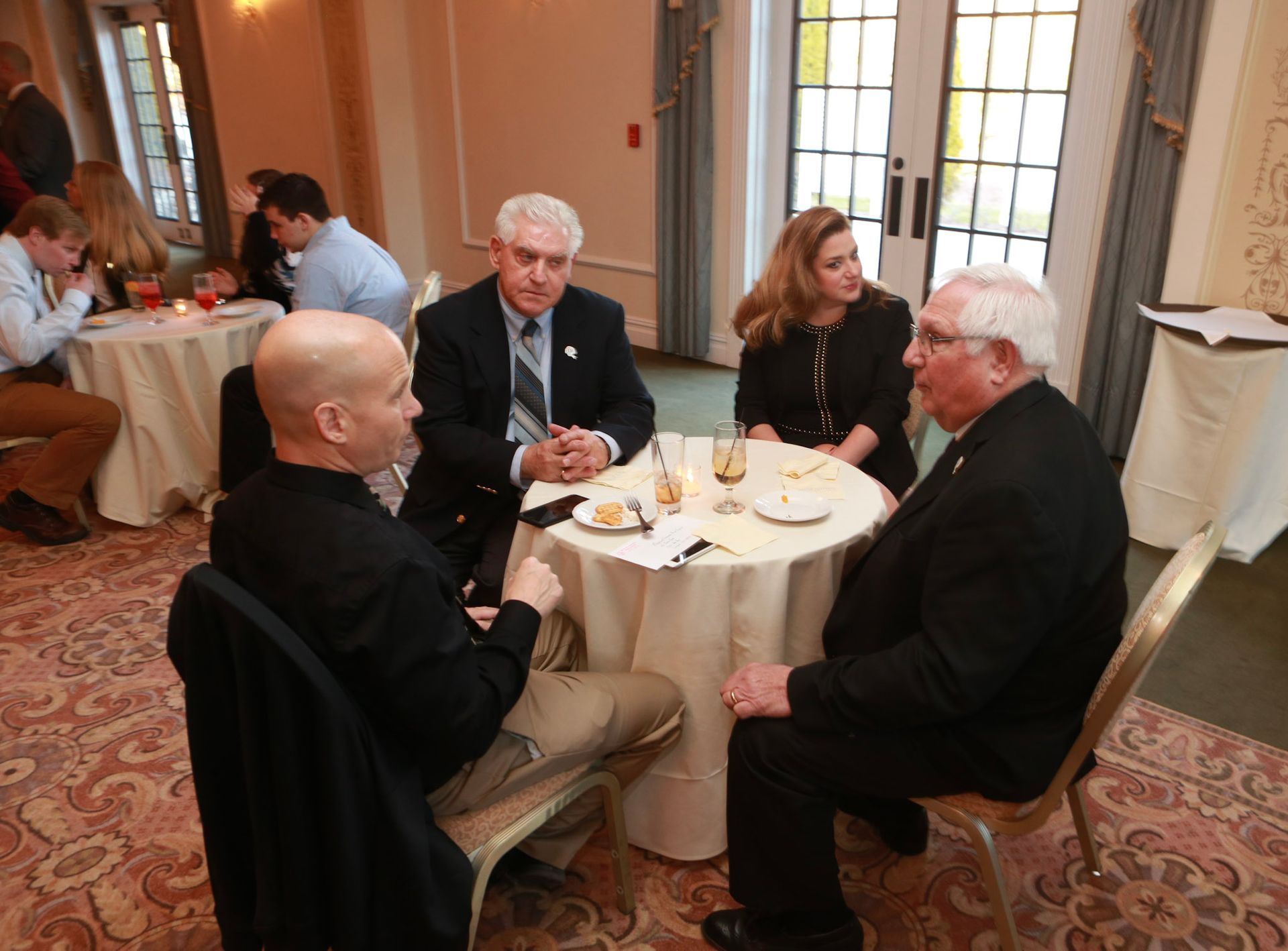 a group of people are sitting around a table talking