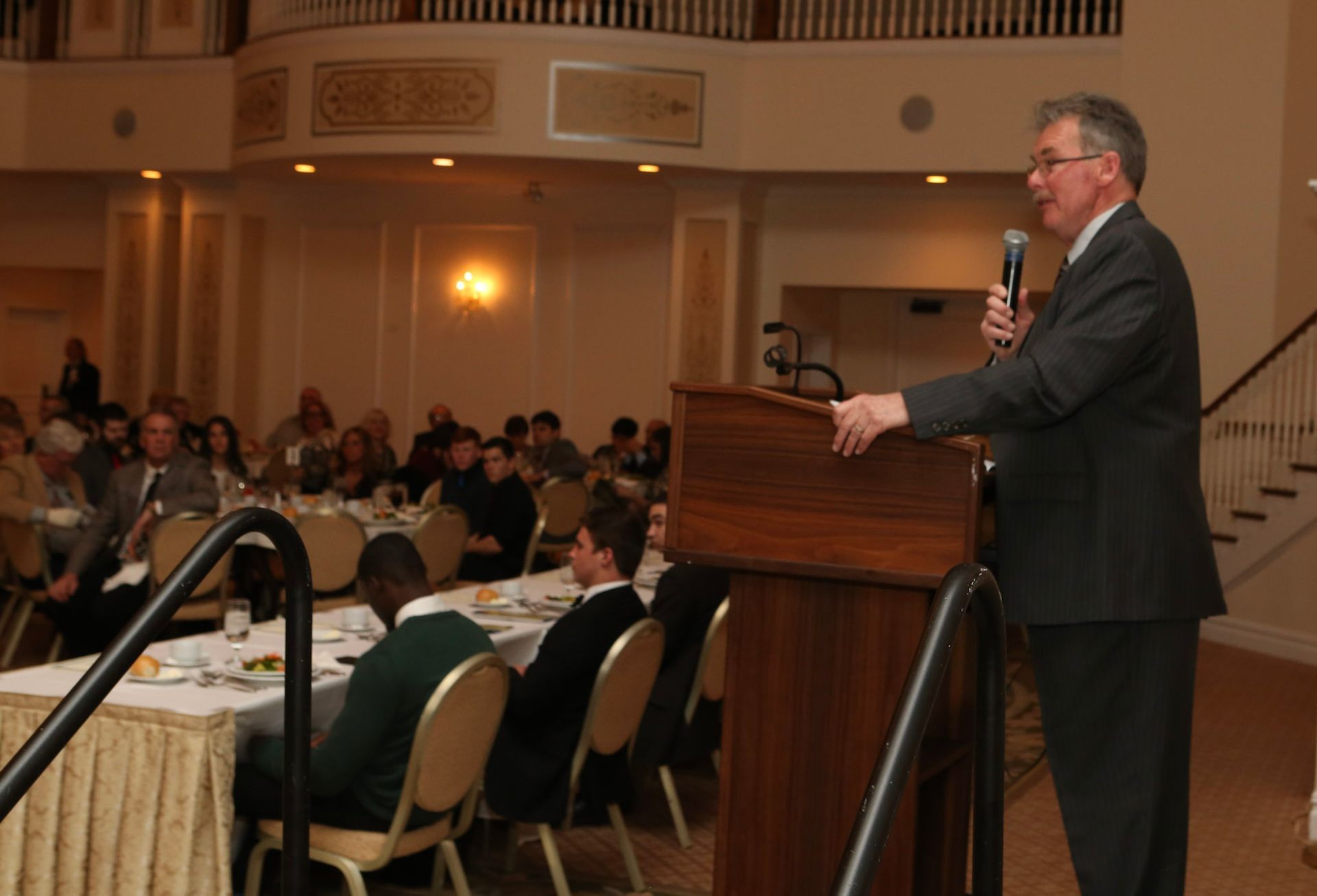 a man stands at a podium speaking into a microphone