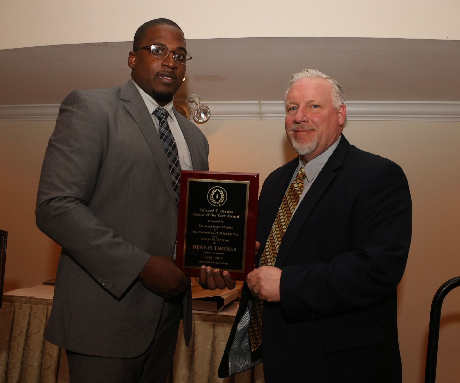 a man in a suit and tie is holding a plaque
