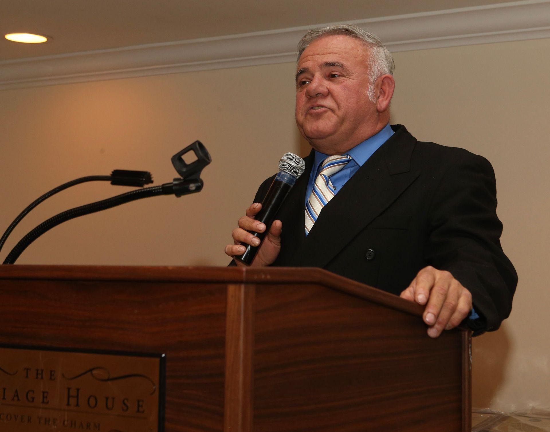 a man stands behind a podium that says the stage house