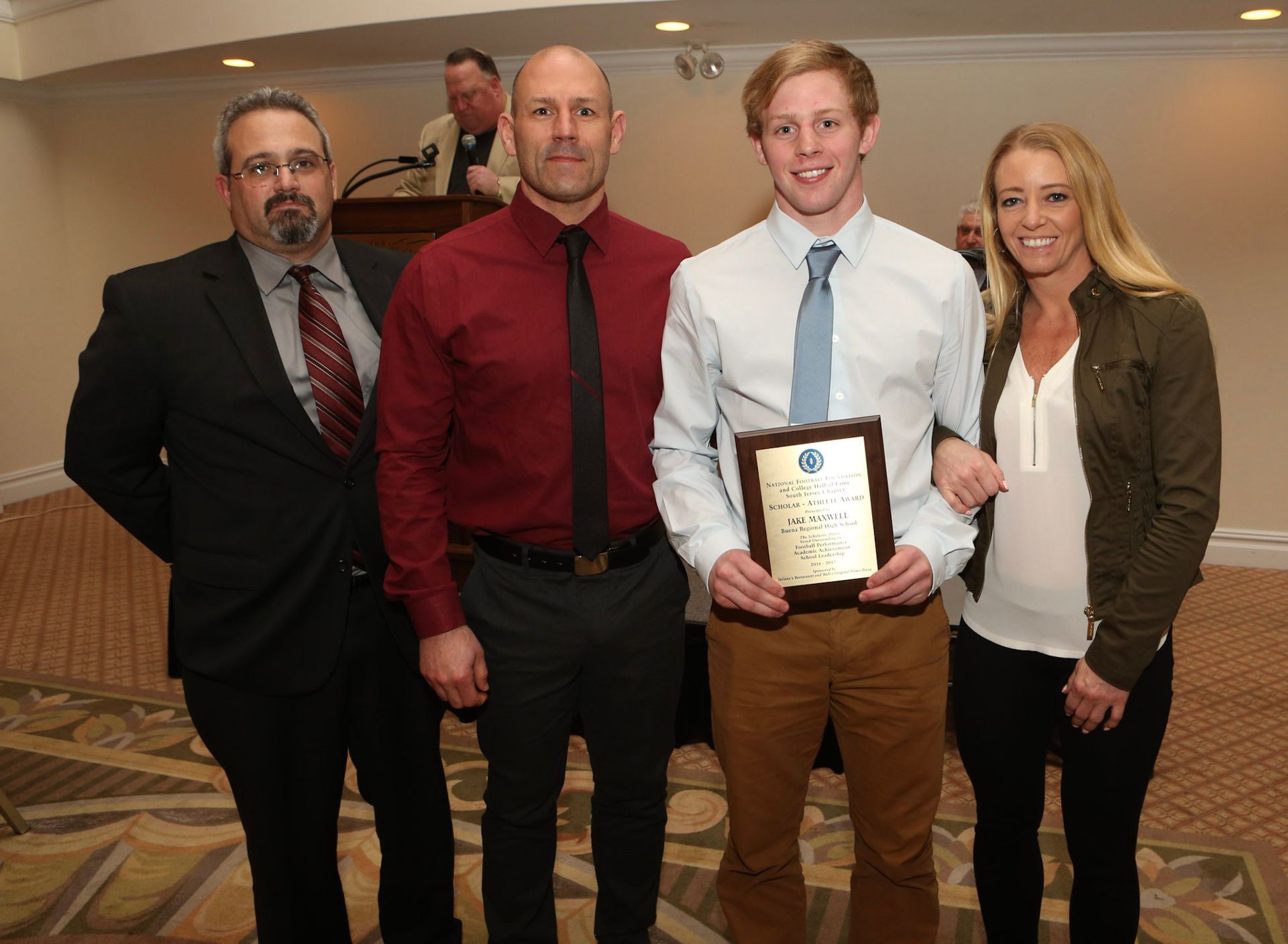 a group of people posing for a picture with one man holding a plaque