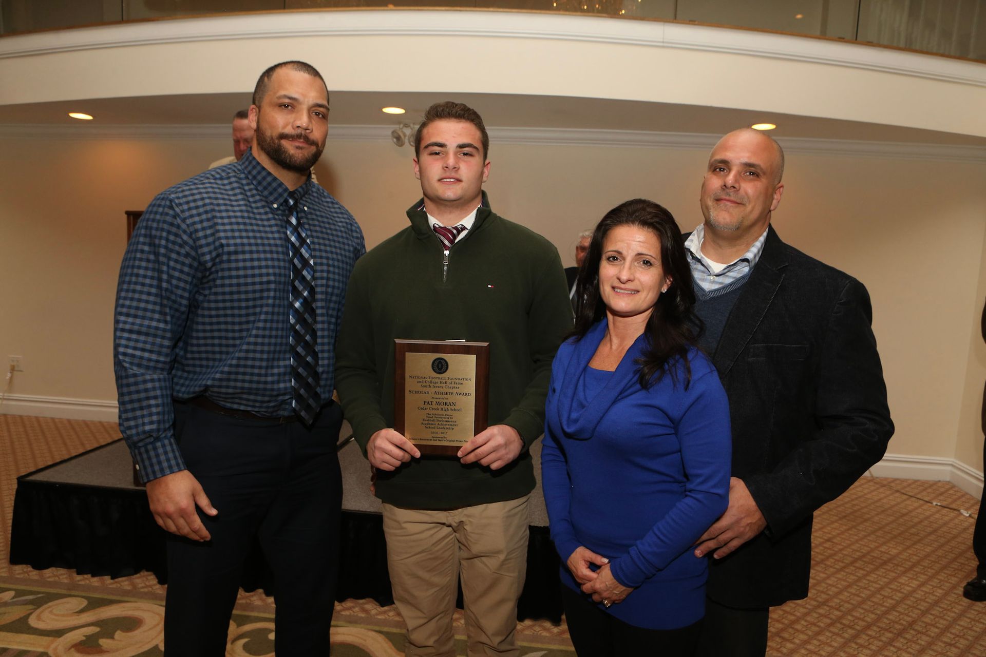 a group of people posing for a picture with a man holding a plaque