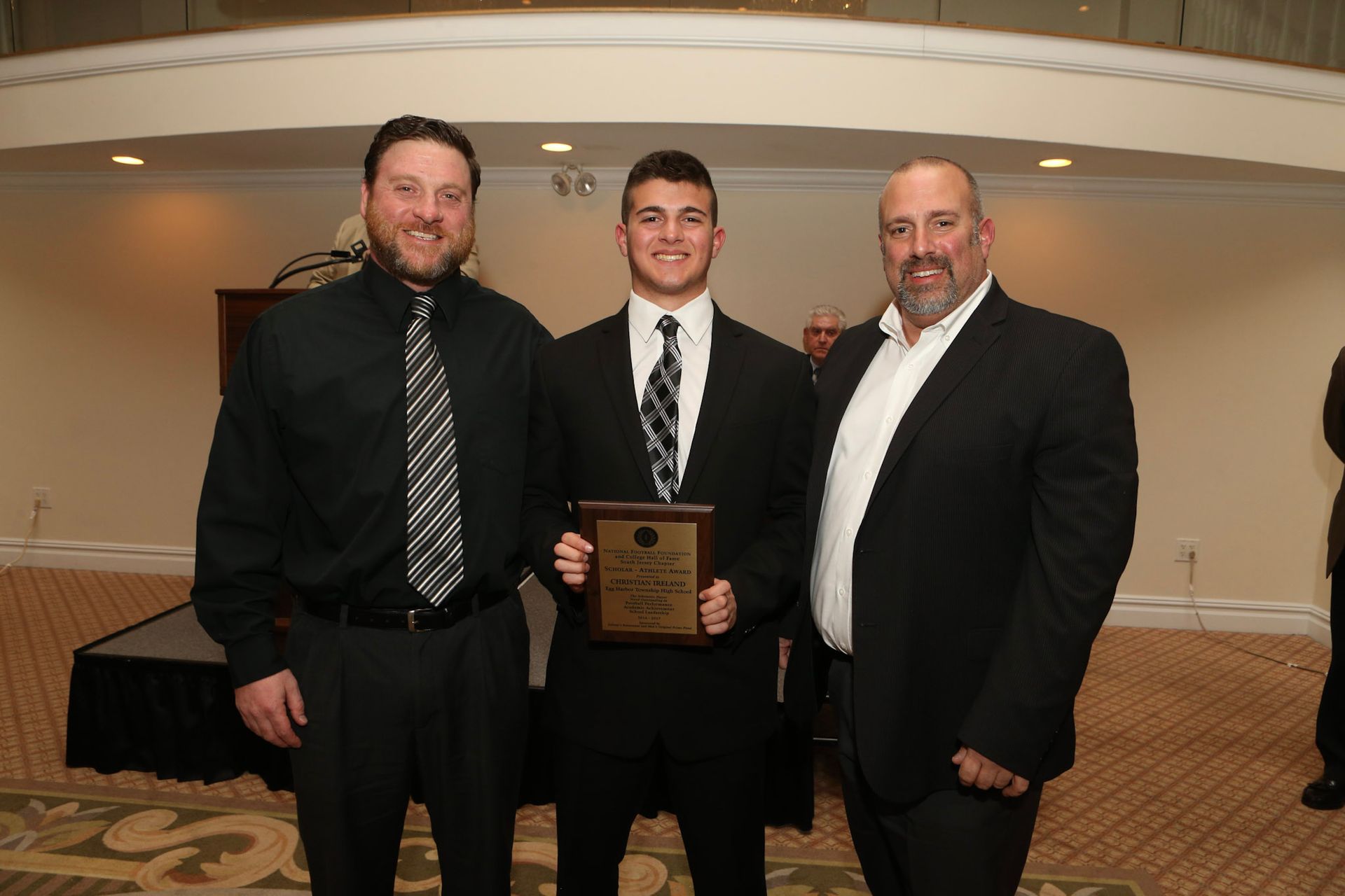 a man in a suit and tie is holding a plaque