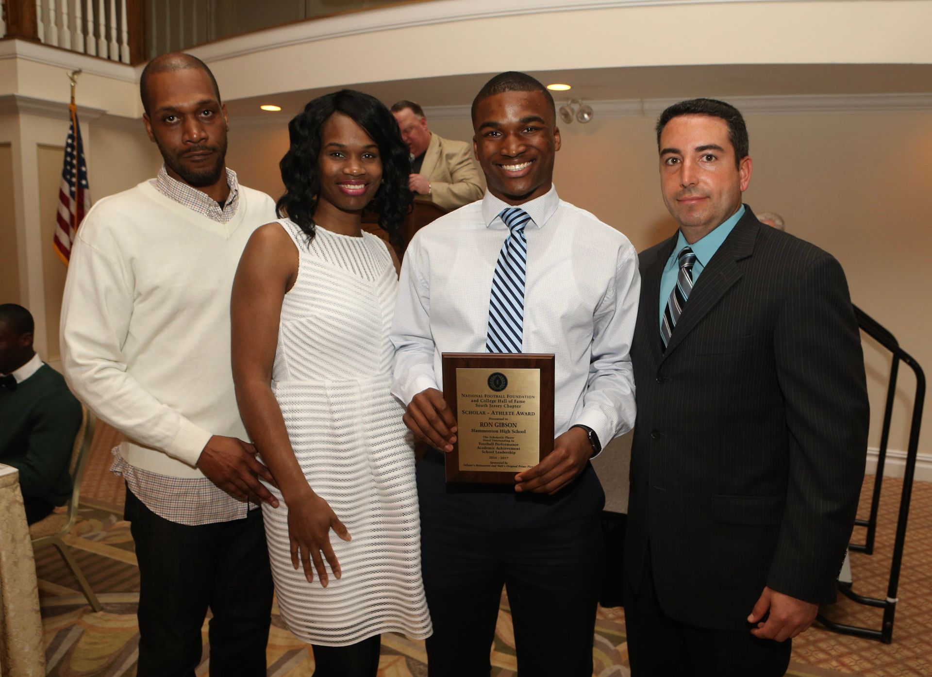 a group of people posing for a picture with one man holding a plaque